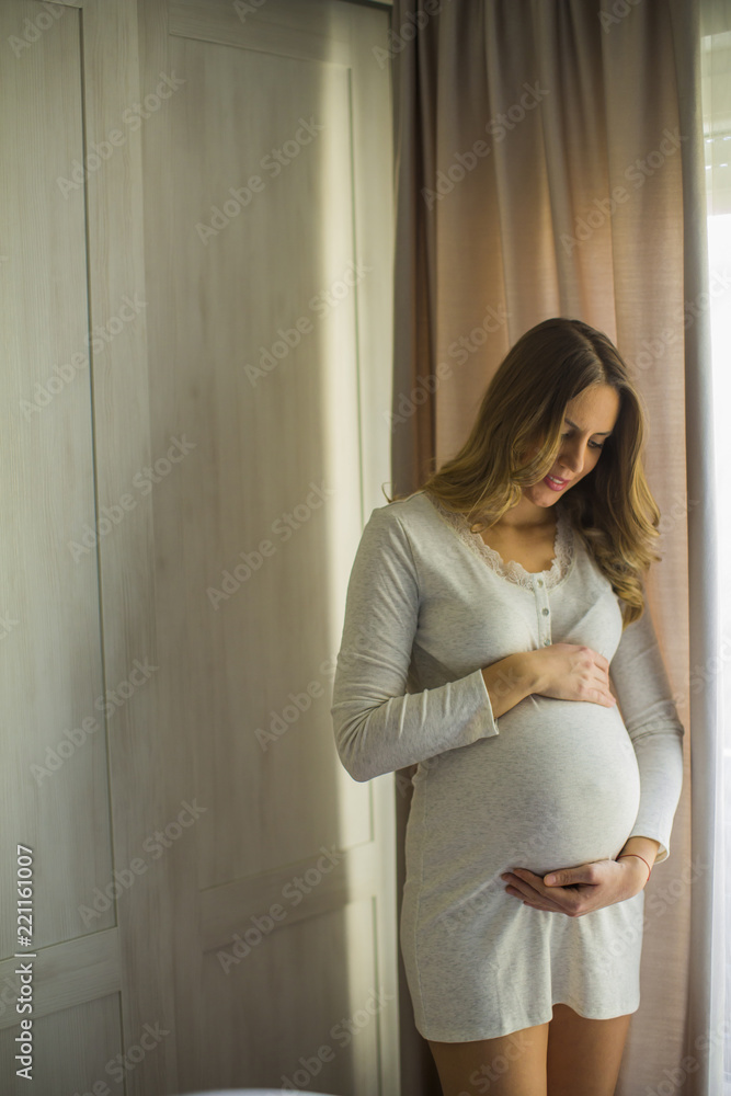 Fototapeta premium Young pregnant woman by the window