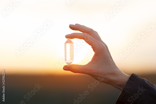 Beautiful woman hands holding little quartz crystals in the sunlight, healing crystal concept shoot, can be used as background