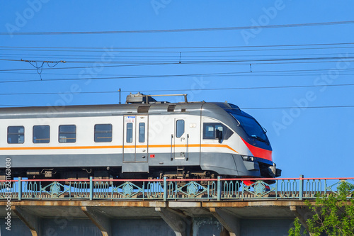 Passenger electric train moves against the clear blue sky