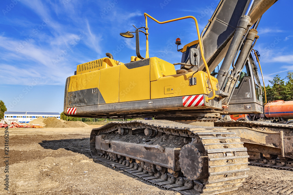 The engine compartment of the excavator, which stands at the construction site. Close-up.