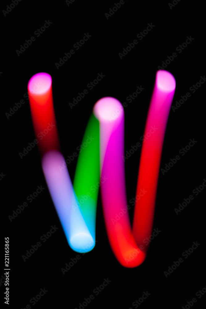 Letter W. Glowing letters on dark background. Abstract light painting at night. Creative artistic colorful bokeh. New Year. Use it for build you own design for book cover, CD, poster or post card. Letter W. Glowing letters on dark background. Abstract light painting at night. Creative artistic colorful bokeh. New Year. Use it for build you own design for book cover, CD, poster or post card.