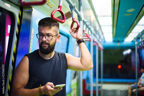 Man using smart phone while taking the subway