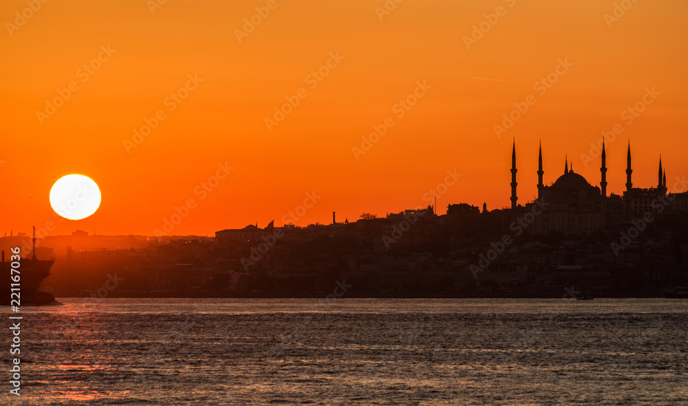 The sun sets over the Bosphorus. Istanbul, silhouette of the Blue Mosque.