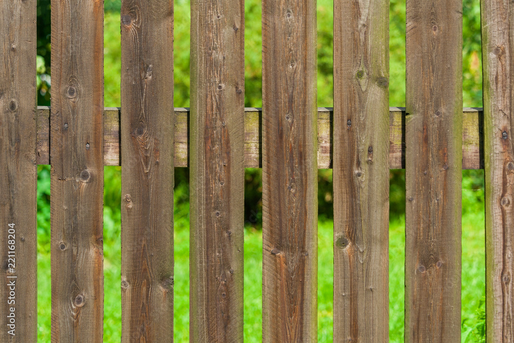 Rural wooden fence a background of green garden Rural wooden fence a background of green garden