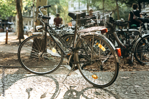 Many bicycles are parked on Leipzig Street in Germany. The photo was taken in the fall at sunset. Ecological transport and a popular means of transportation in Europe.