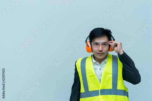Asian engineer with wear helmet and safety glasses,He has a walkie talkie in hand,Thailand smart people © reewungjunerr
