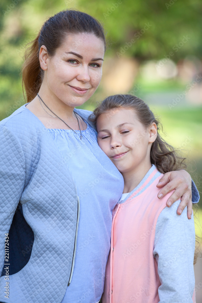 Mother with her young daughter stand embracing, girl with closed eyes Mother with her young daughter stand embracing, girl with closed eyes