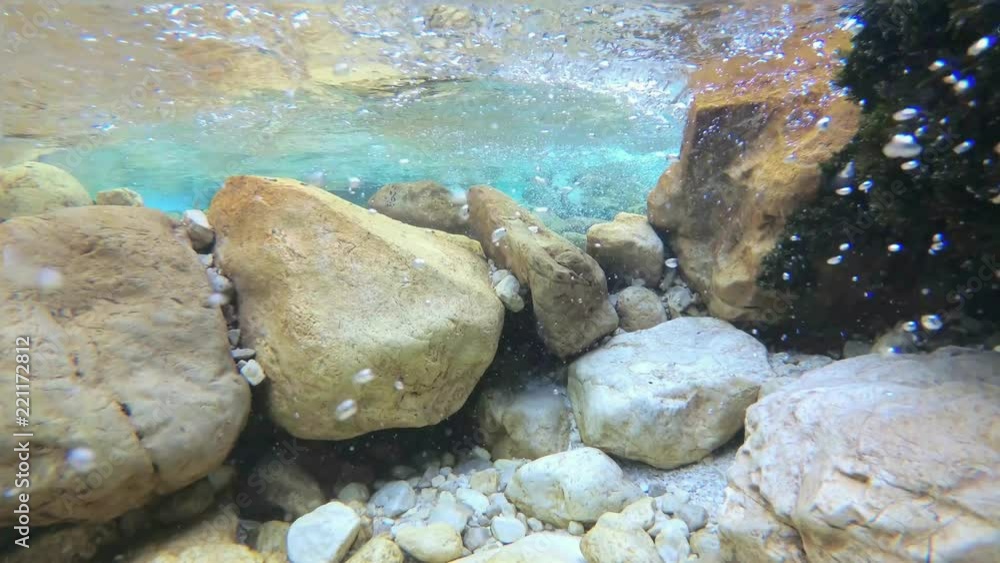 Super slow motion underwater: Amazing mountain river flow with bubbles and turquoise water. UHD