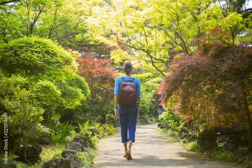 A girl is walking in a sunny garden and park on Jeju Island in Korea