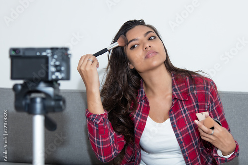 Latin american vlogger girl presenting cosmetics in video blog