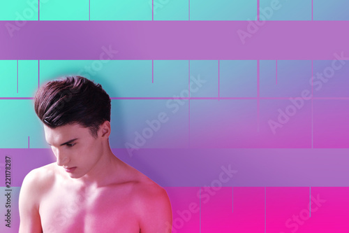 Shower time. Calm young man wearing no clothes and looking thoughtful while standing in a shower