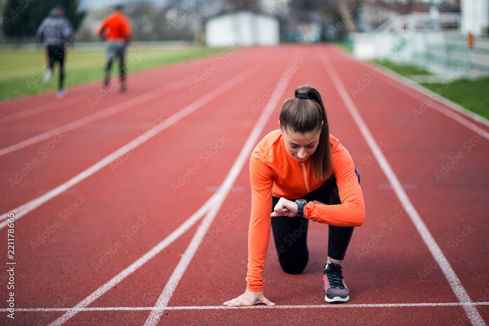 Female athlete on the starting line of a stadium track,ready to run