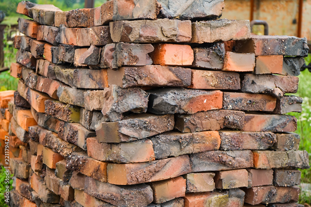 Defective red clay bricks are stacked on wooden pallets. Waste production of bricks from clay. Copy space Defective red clay bricks are stacked on wooden pallets. Waste production of bricks from clay. Copy space