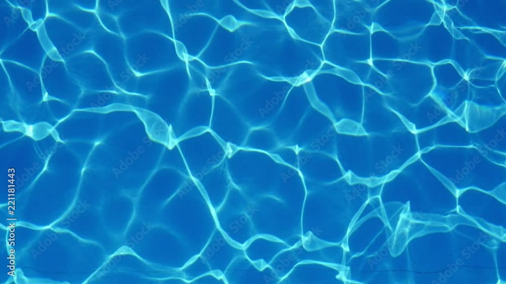 Up down view of swaying light blue waters in a spacious and luxury looking swimming pool with sparkling lines forming a nice background. Up down view of swaying light blue waters in a spacious and luxury looking swimming pool with sparkling lines forming a nice background.