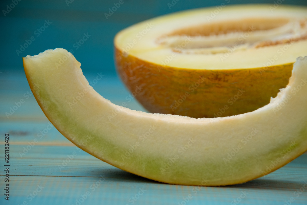 half ripe melon on a rustic, blue wooden background
