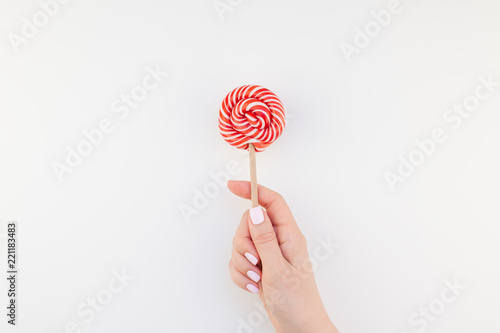 Woman hand with red lollipop
