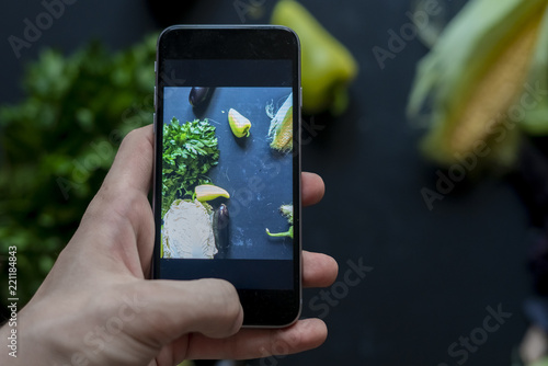 close up hands over the dark table making a food product photography with phone