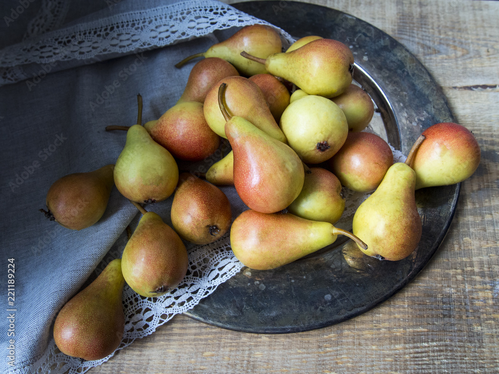Fresh pears on a tray, rustic wooden background