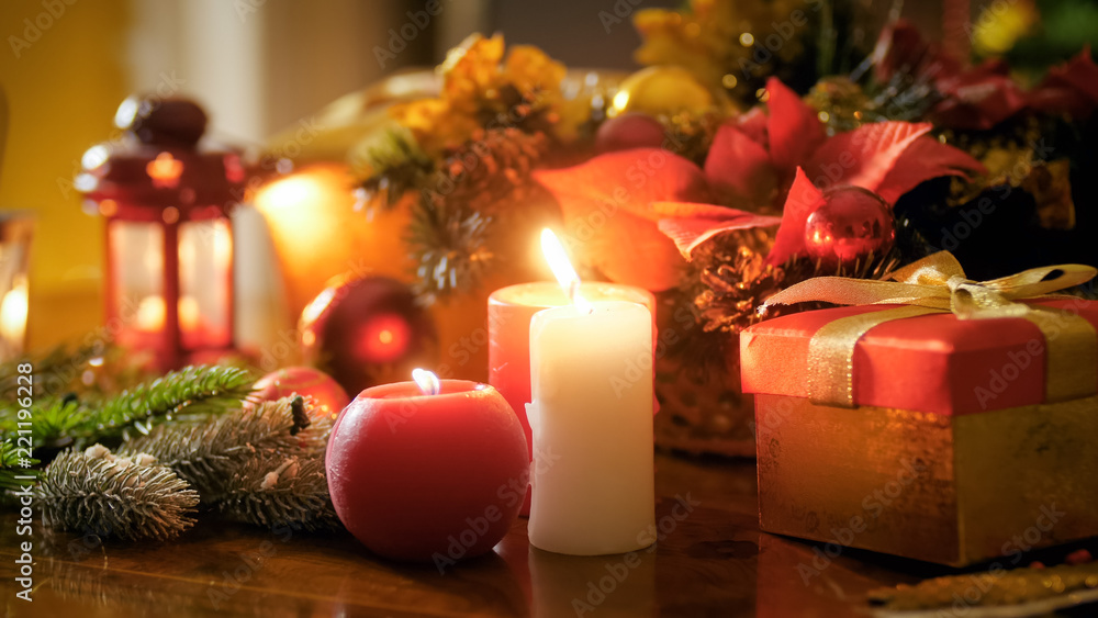 Closeup image of candles and lanterns on table decorated for Christmas