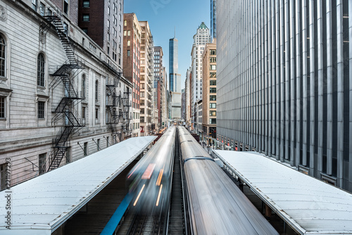 Two trains of the Chicago metro system crossing the elevated railroad in a skyscrapers canyon in the Loop district, Chicago, Illinois, United States