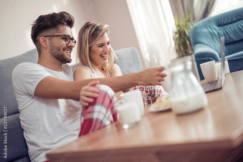 Young couple in they living room using laptop Young couple in they living room using laptop
