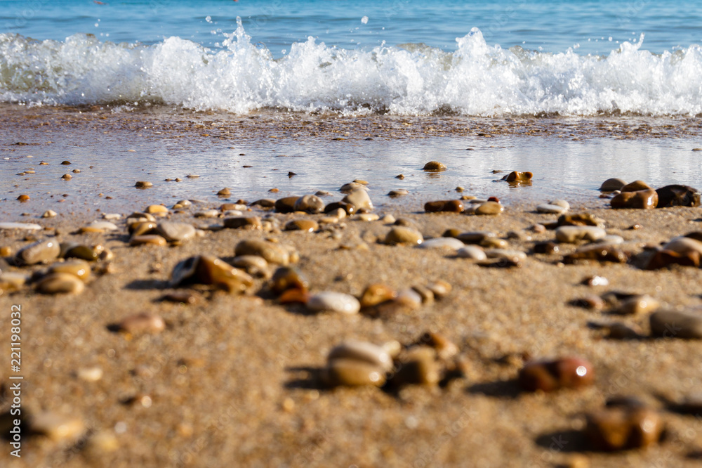 Relaxing sea waves on the coast with sand and stones