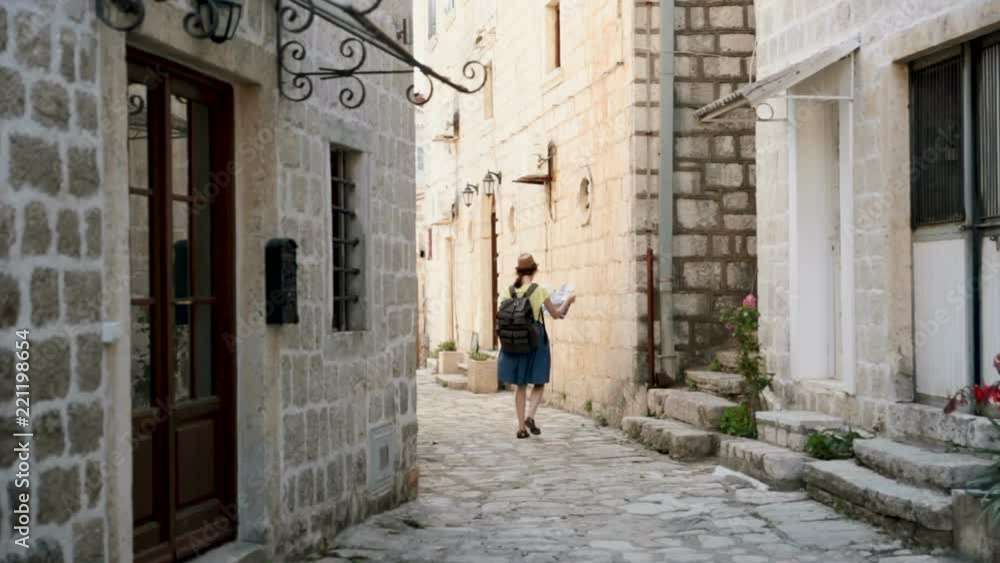 Young happy woman in hat traveling at Montenegro and looking landmarks, hipster girl with map at the city center, urban scene. Attractive woman traveling at Europe. Young happy woman in hat traveling at Montenegro and looking landmarks, hipster girl with map at the city center, urban scene. Attractive woman traveling at Europe.
