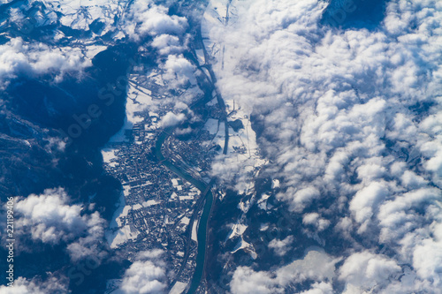 Blue planet Earth seen from high above through an airplane window. Unique panoramic high altitude aerial view of thunderstorm clouds cumulus over snow-capped mountain region of south central Europe.