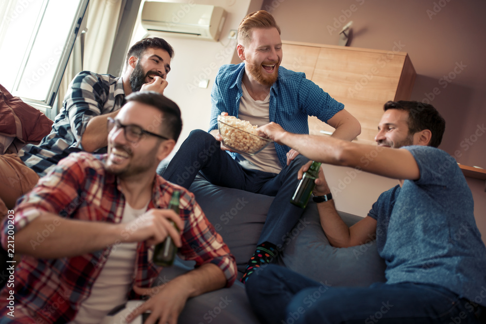 Obraz na plátně Happy male friends drinking beer at home