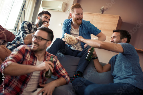 Photography Happy male friends drinking beer at home