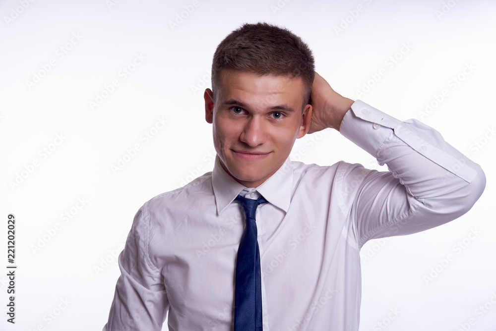 a handsome man in a white shirt and tie with his left hand scratches the back of his head a handsome man in a white shirt and tie with his left hand scratches the back of his head