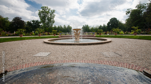 Large squirting fountain with several Greek mythology statues, angels of marble in a baroque garden surrounded