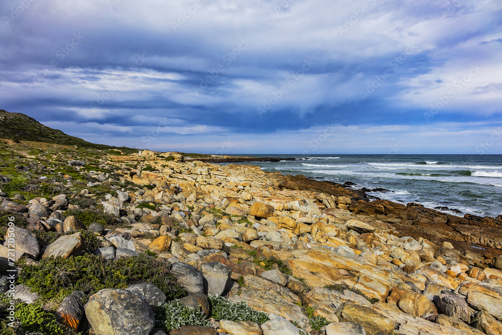 Picturesque view of the rocky shoreline of Atlantic Ocean and Platboom Beach. Platboom Bay is a beautiful beach along coastline nestled in Cape of Good Hope Nature reserve, Cape Town, South Africa.
