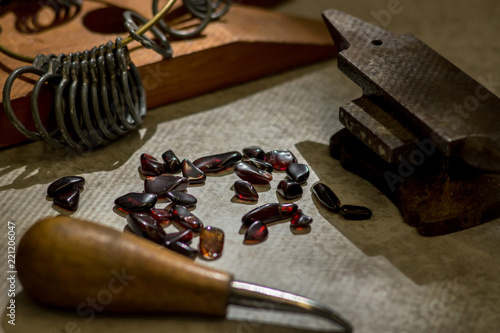 Raw red garnets surrounded by jewelry making tools.