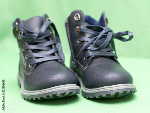 children s black boots on a green background