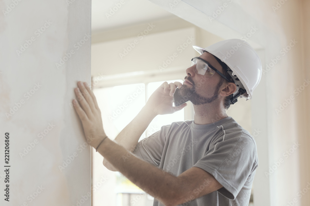 Professional builder working and having a phone call Professional builder working and having a phone call