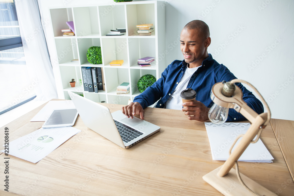 Image of african american businessman working on his laptop. Handsome young man at his desk Image of african american businessman working on his laptop. Handsome young man at his desk