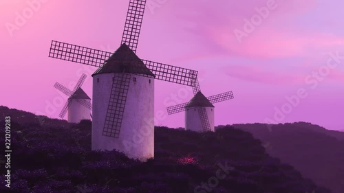 Multiple white, classic spanish windmills in the field during beautiful sunset.