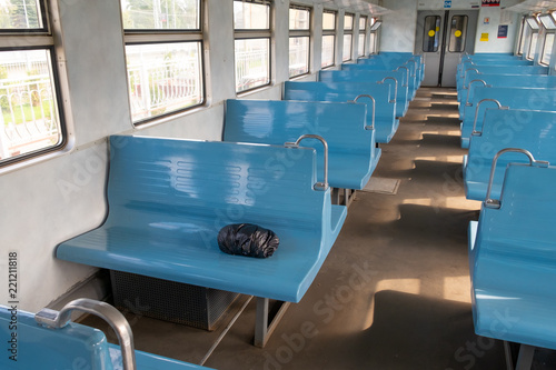 the black package lies in the empty passenger train on a seat. package of unknown contents