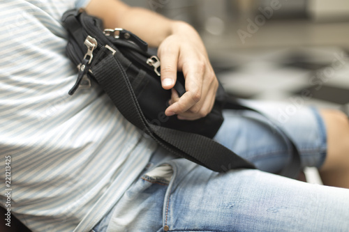 a man is afraid and sits in his hand a black purse with money
