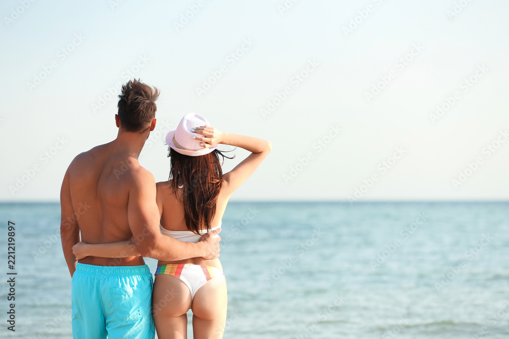 Happy young couple at beach on sunny day Happy young couple at beach on sunny day