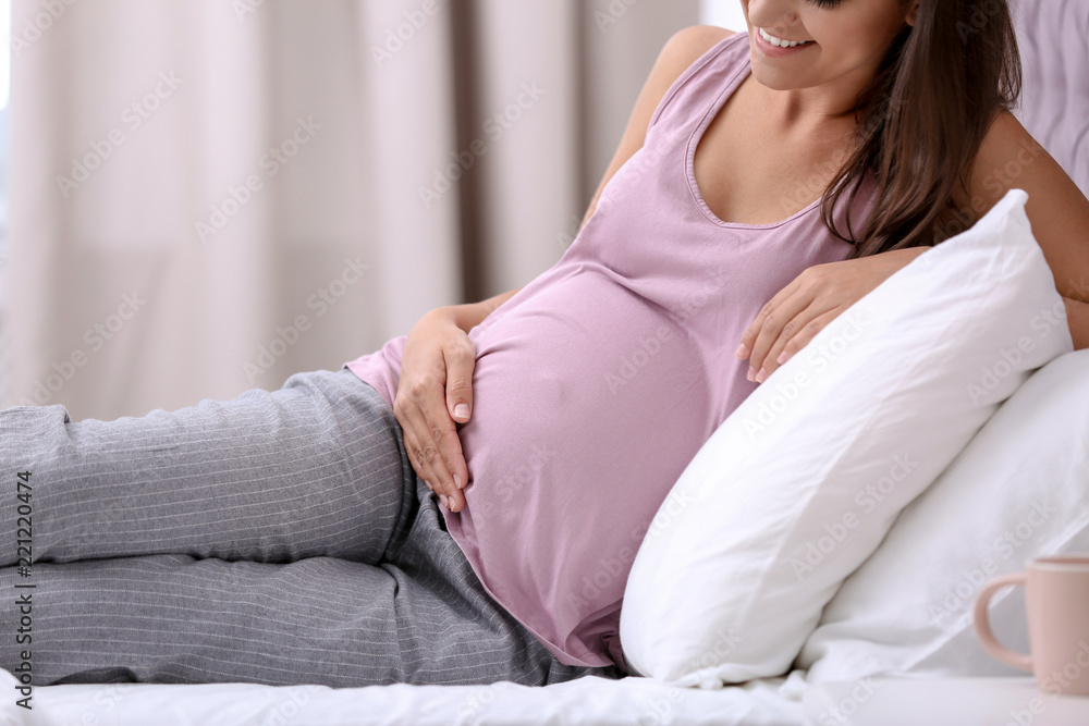 Happy pregnant woman lying on bed at home, closeup Happy pregnant woman lying on bed at home, closeup