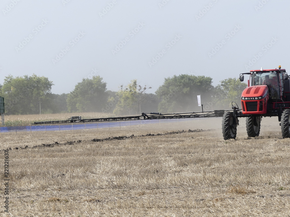 Fototapeta premium Exhibition of agricultural machinery. Agrotechnics works in the field. The tractor lights the field. Irrigation machine.