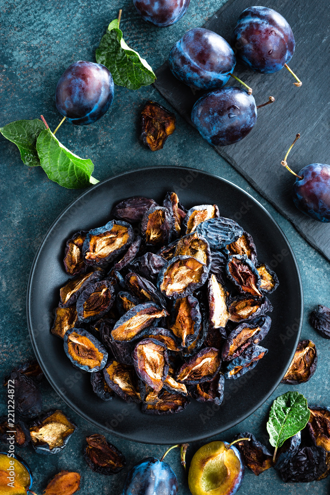Dried prune and fresh plums with leaves Dried prune and fresh plums with leaves