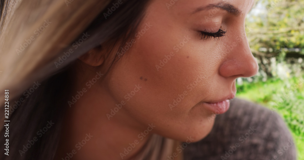 Fototapeta premium Extreme close-up of wind blowing hair of gentle young lady in nature setting