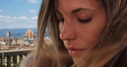 Extreme close-up of pretty female with hair flowing in wind in Florence, Italy