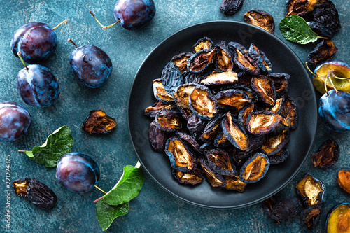 Fotografía Dried prune and fresh plums with leaves