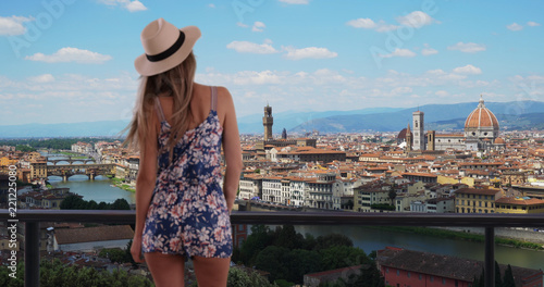 Rear shot of millennial girl in romper enjoying view of Florence cityscape