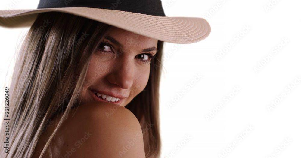Close-up of woman wearing hat looking over her shoulder on white copy space Close-up of woman wearing hat looking over her shoulder on white copy space