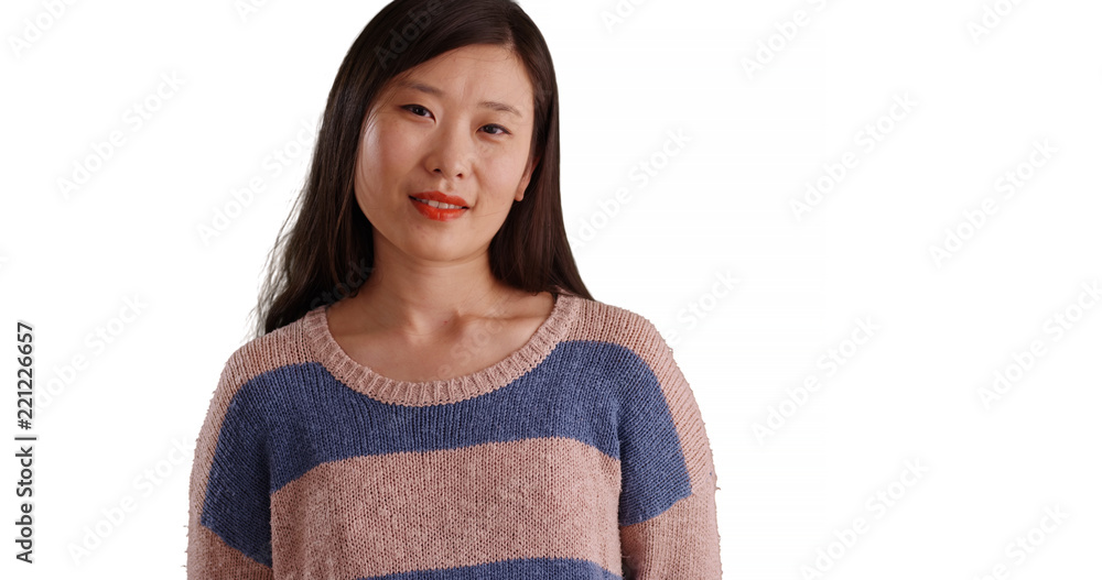 Close up of pleasant millennial woman wearing a sweater in front of copyspace Close up of pleasant millennial woman wearing a sweater in front of copyspace